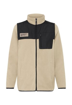 Bež flis jakna s crnim panelom, zatvorenim džepom i logotipom. Ima visoki ovratnik i bočne džepove. Mekana tekstura, ležeran dizajn.