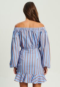 Off-Shoulder-Kleid aus hellblauem Stoff mit braunen vertikalen Streifen, Glockenärmeln, taillierter Passform und Rüsche am Saum.