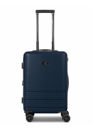 Navy hardshell suitcase with vertical ribbed texture, telescoping handle, and four spinner wheels. Features a logo on front panel.