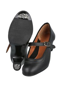 Zapatos Mary Jane de cuero negro con punta redondeada, correa ajustable y acentos decorativos en plata en el talón. Textura suave, diseño clásico.