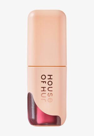 Contenant de teinte pour les lèvres House of Hurr de couleur pêche avec une partie transparente montrant une couleur rouge foncé à l'intérieur.