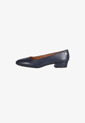 Zapato de tacón bajo para mujer de cuero azul marino con punta redonda y pequeño tacón cuadrado, con forro interior color tostado y detalle de tachuelas metálicas cerca del tacón.