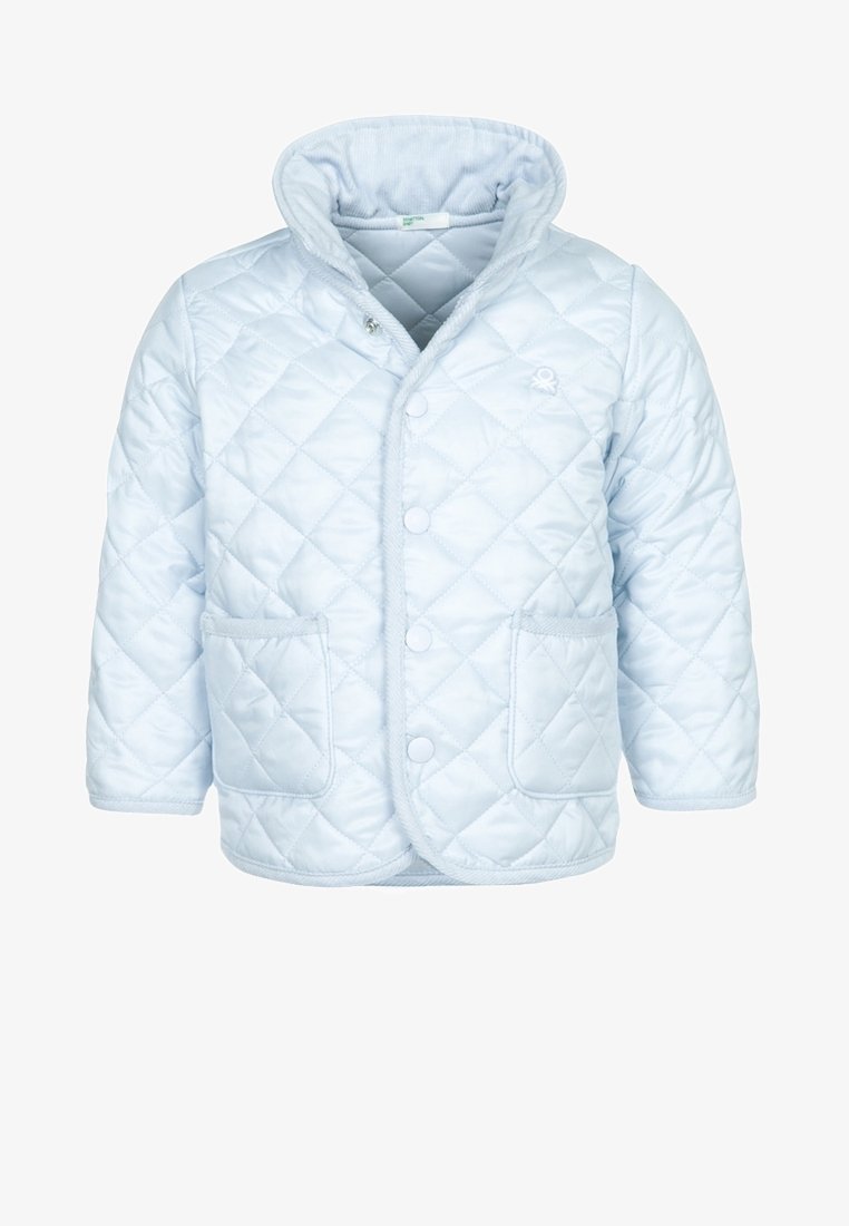 Světlomodrá prošívaná bunda s vysokým límcem, druky, dvěma předními kapsami a texturovanou vnitřní podšívkou. Vyznačuje se prošíváním ve vzoru diamantů.