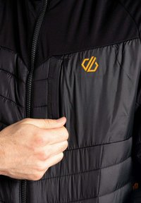 Schwarze Daunenjacke mit Reißverschluss und orangefarbenem Logo; verfügt über ein gestepptes Quiltmuster und kontrastierendes glattes Material an den Schultern.
