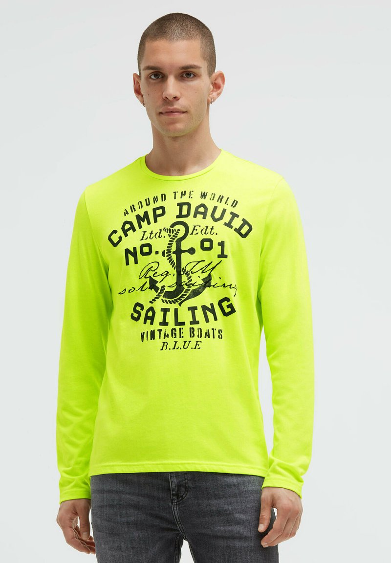 Langärmeliges Neon-Gelb T-Shirt mit schwarzem grafischem Text und Anker-Design. Verfügt über einen Rundhalsausschnitt und eine weiche, glatte Textur.