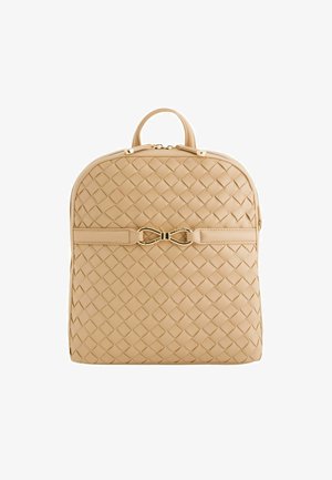 Geweven beige leren rugzak met een gebogen bovenkant, gouden hardware en een decoratieve strikaccent aan de voorkant. Gladde textuur, ritssluiting.