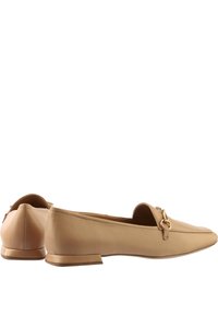 Beige leather loafers with a pointed toe and minimalistic design. Features a small gold hardware detail at the front and a low, flat heel.