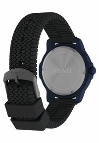 Melnas gumijas pulksteņa josta ar protektora rakstu, sudraba nerūsējošā tērauda aizmugure, zila korpusa krāsa un pelēks sprādzes mehānisms. Iezīme ir apaļa forma.