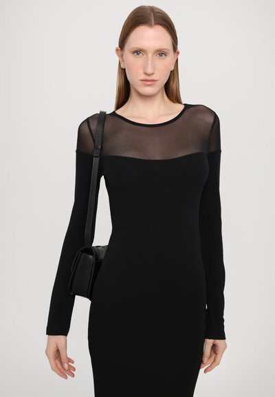 Musta pikad varrukad dress, millel on läbipaistev ülaosa, tihe kuju, pehme tekstuur, millele on lisatud väike must käekott.