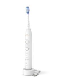 Brosse à dents électrique avec un manche en plastique blanc, une tête de poils bleu et blanc, un bouton d'alimentation et trois boutons de mode à l'avant, reposant dans un support de chargement.