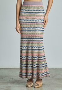 Gebreide maxi-jurk met een meerkleurig gestreept patroon in roze, groen, blauw en beige, met een aansluitende tailleband en uitlopende onderkant.