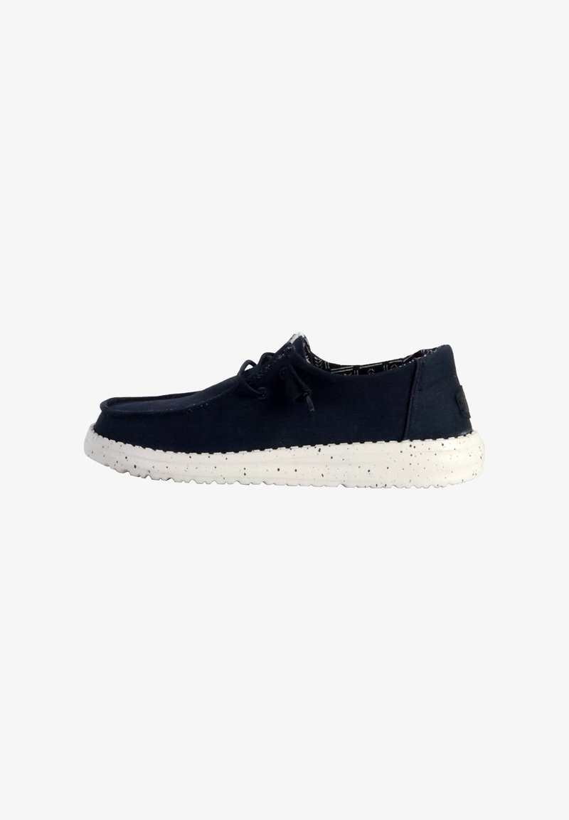 Scarpa in suede blu navy con suola bianca maculata, design con lacci e fodera stampata. Presenta una punta arrotondata e una silhouette slanciata.