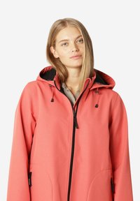 Chaqueta con capucha de color coral con un acabado texturizado, cremallera frontal y bolsillos laterales, con herrajes negros y cordones ajustables.