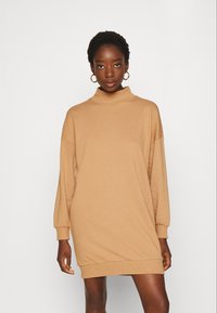 Kuhansweater-mekko, rento malli, korkea kaulus, valuvat hartiat, pitkät hihat, ribbaushelma ja -hihansuut, pehmeä tekstuuri, minimaalinen muotoilu.