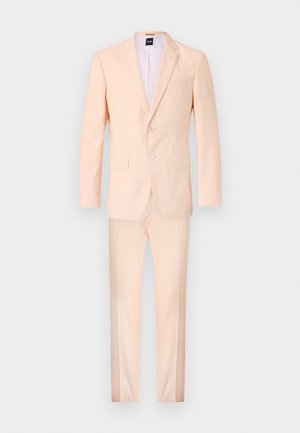 Conjunto de fato em pêssego claro, apresentando um blazer ajustado com dois botões e calças coordenadas. Textura suave e corte clássico.