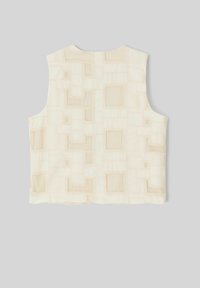 Haut sans manches de couleur crème avec un motif géométrique texturé comportant des accents carrés en matériau contrastant. Tissu doux et léger.