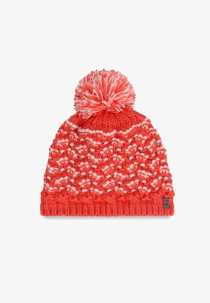 Knit beanie in bright coral with white accents, featuring a textured pattern, a large striped pompom on top, and a ribbed cuff.