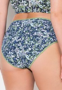 Mutande da donna con motivo floreale in blu navy, verde e bianco; materiale in cotone con una texture morbida e una cintura verde a contrasto.