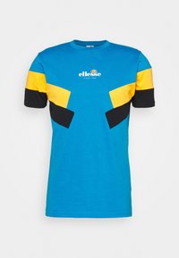 Camiseta azul de manga corta con acentos de bloques de color amarillos y negros en diseño geométrico. Presenta un cuello redondo y un logo impreso en el frente.