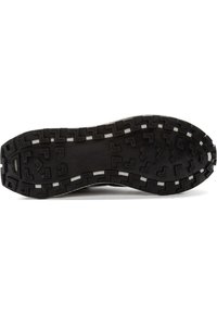 Svart gummisula med ett texturerat greppmönster och vinklade mönster. Har vitt sömnad längs kanten och en platt profil.