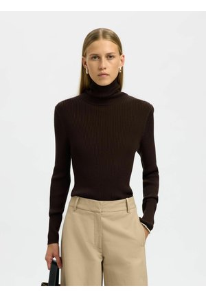 Ribbed turtleneck sweater in dark brown, fitted design with long sleeves, paired with beige trousers; subtle texture and seamless finish.