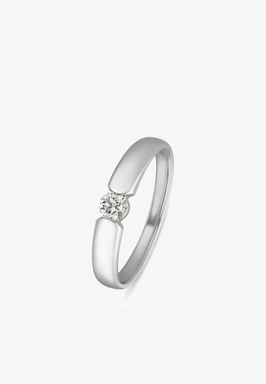 Silberner Ring mit einem einzelnen runden klaren Edelstein, der zwischen zwei glatten, leicht gebogenen Bandenden auf weißem Hintergrund gefasst ist.