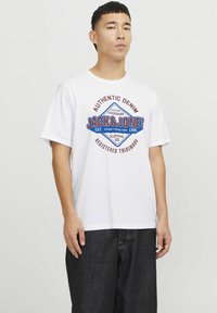 Witte katoenen t-shirt met een blauw en rood grafisch logo gecentreerd op de borst, met de tekst "AUTHENTIC DENIM JACK & JONES."