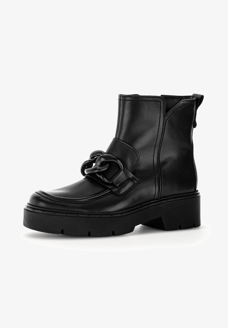 Bottes basses en cuir noir avec une semelle épaisse, ornées d'un nœud décoratif prononcé à l'avant et de détails de couture verticale.