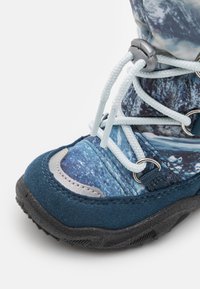 Blaue und graue Stiefel mit Obermaterial aus Wildleder und Stoff, strukturierte Oberfläche, Schnürdetails und robuster schwarzer Gummisohle. Verfügt über metallische Akzente.