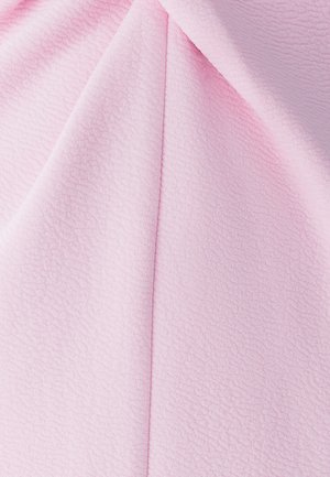 Helles rosa Textil mit einer weichen, plüschigen Oberfläche, die subtile Rillen aufweist und einen geschmeidigen Fall hat. Geeignet für verschiedene textile Anwendungen.