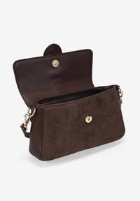 Bolso cruzado de ante marrón con cierre magnético, detalles en hardware dorado y un compartimento interior con cremallera. Presenta una forma rectangular elegante.