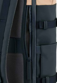 Tmavě modrý batoh s prodyšnou podšívkou, několika zipovými přihrádkami, nastavitelnými popruhy a texturovanými akcenty pro zvýšenou odolnost.