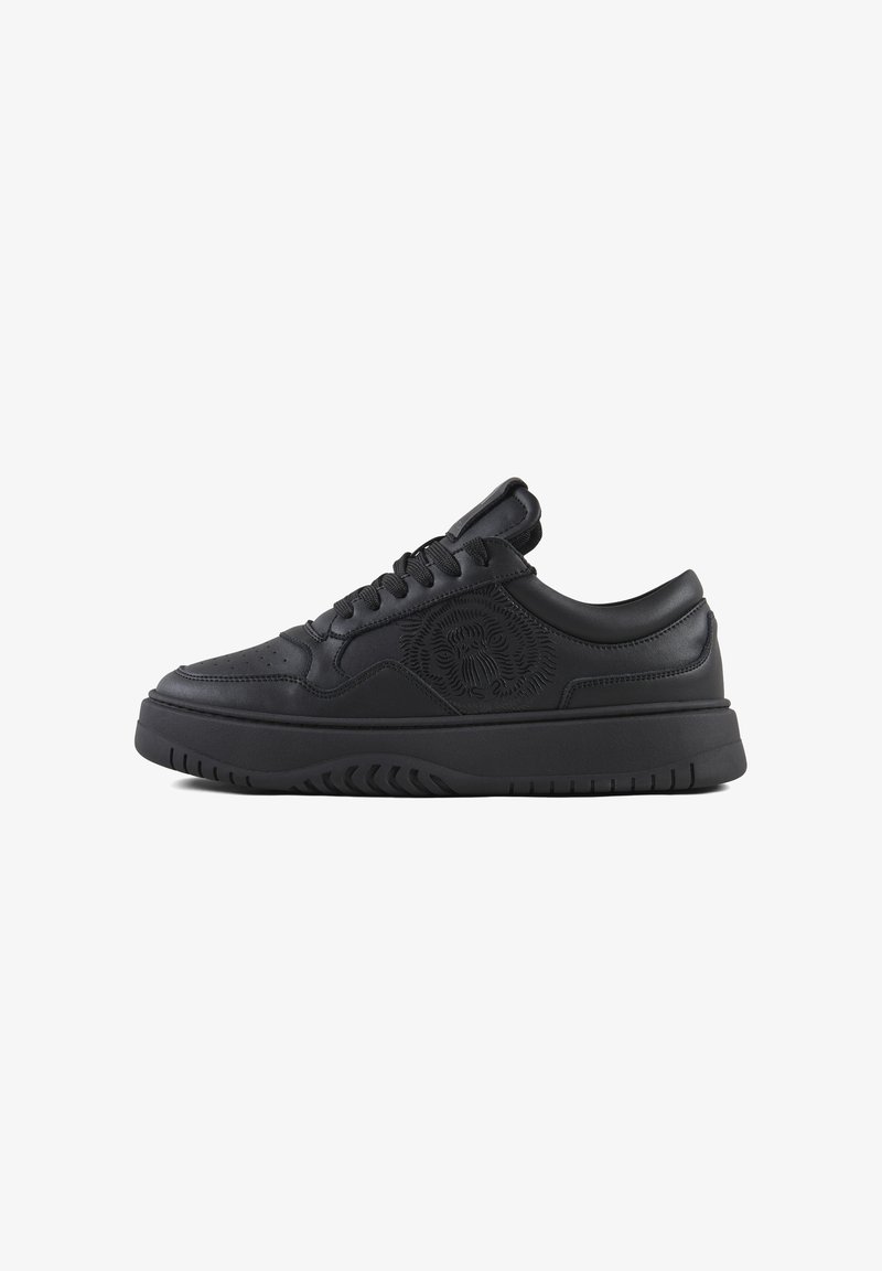 Zapatillas de cuero negro con punta perforada, logotipo de león en relieve y suela de goma gruesa. Cuenta con cordones planos y lengüeta acolchada para mayor comodidad.