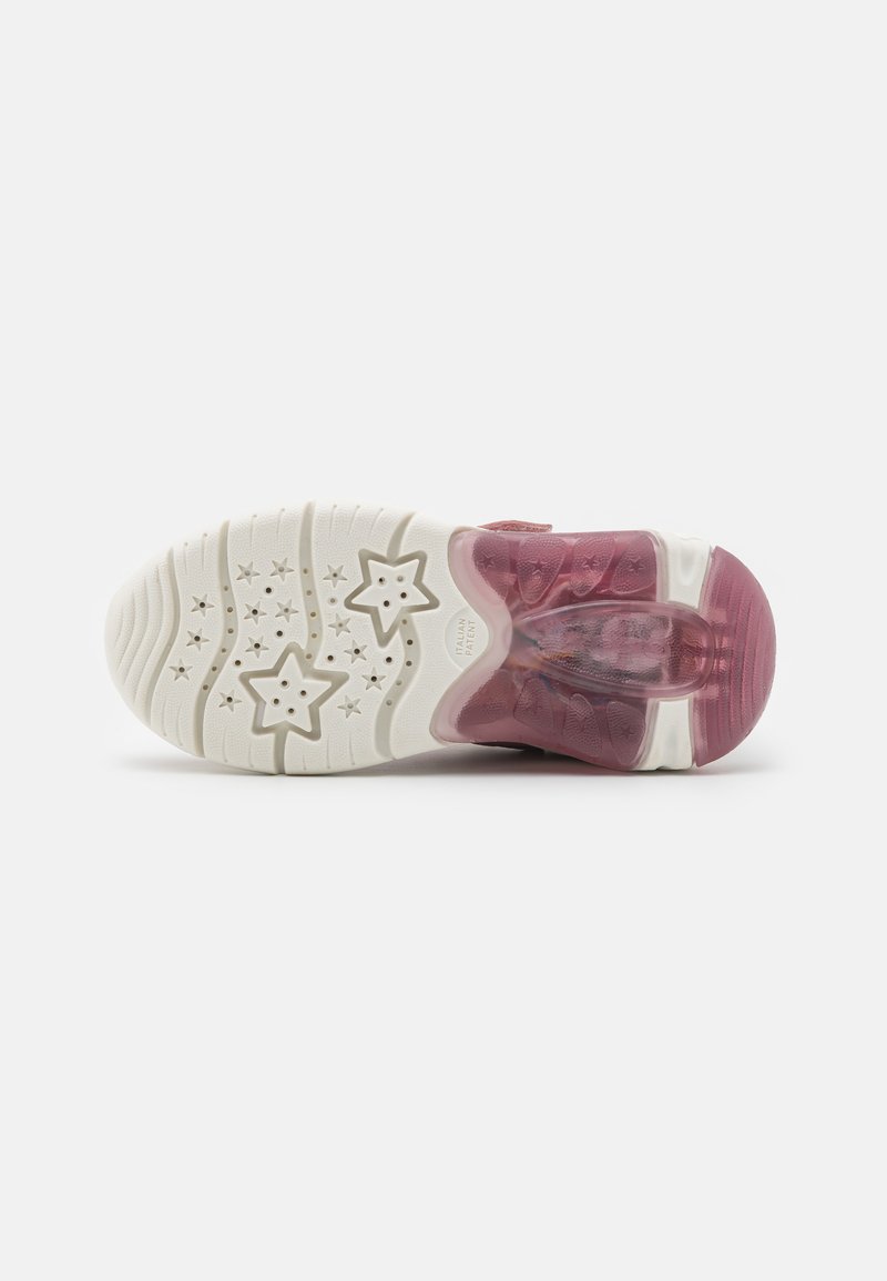 Semelle de chaussure avec une base en caoutchouc blanc ornée de motifs étoilés. Le talon présente un dégradé de violet à transparent, mettant en avant des détails de rembourrage.