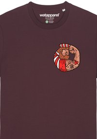 Burgunderfarbendes Baumwoll-T-Shirt mit einer bunten Cartoon-Illustration einer flexenden, muskulösen Figur mit einem gestreiften Hut auf der Brust.