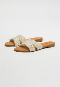 Sandalias deslizantes blancas bordadas con un patrón floral decorativo, plantilla marrón suave, suela plana y diseño sencillo. Apta para el uso diario.