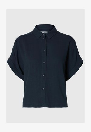 Sötét tengerészkék, rövid ujjú ing, galléros nyakkal, gombos elülső résszel és sima textúrával. Laza szabású, felgöngyölt ujjak jellemzik, és minta nincs rajta.