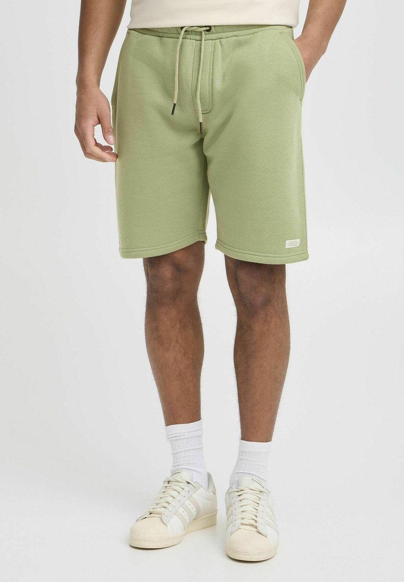 Lysegrønne bomulds-sweatshorts med elastisk talje, snørre, sidelommer og et vævet mærke ved bundkanten.