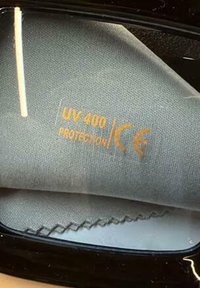 Schwarz gerahmte Sonnenbrille mit einem grauen Mikrofasertuch zum Reinigen, das im Bereich der Linse mit der Aufschrift "UV 400 Schutz CE" versehen ist.