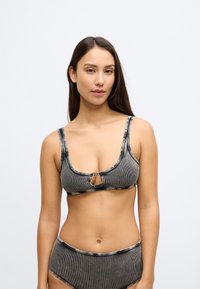 Μπικίνι τοπ με γκρι και μαύρες ρίγες, με στρογγυλή λαιμόκοψη, λεπτομέρεια με άνοιγμα στο κέντρο και φαρδιές τιράντες. Λεία υφή υφάσματος, ελάχιστα μεταλλικά στοιχεία.