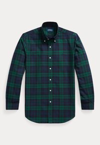 Chemise à manches longues boutonnée avec motif à carreaux verts et bleu marine et col boutonné, posée à plat sur un fond uni.
