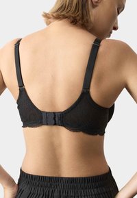 Sort blonde-bh med justerbare stropper, der har lukning med hægte og øje bagpå samt blødt, tekstureret stof. Ingen yderligere mønstre synlige.
