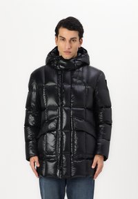 Jachetă puffer neagră cu un design lucios, matlasat, având glugă, nasturi și două buzunare frontale. Fabricată dintr-un material ușor și neted.
