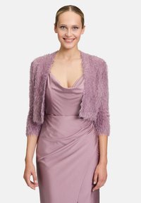 Châle en fausse fourrure lilas avec des manches trois-quarts sur une robe en satin lilas avec des détails drapés et un décolleté en V. Texture douce et légère brillance.