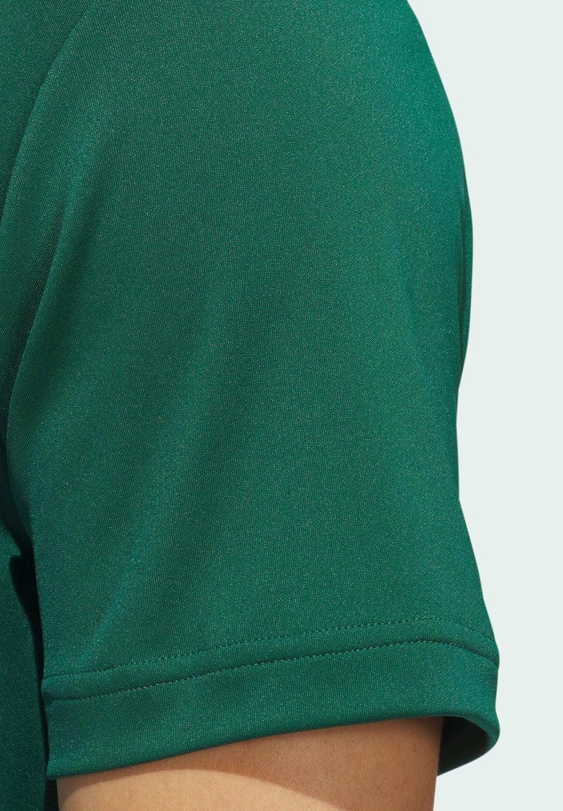 Grünes Sport-T-Shirt mit einer glatten Textur, kurzen Ärmeln und einem geraden Saum. Der Stoff hat einen leichten Glanz.