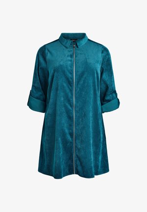 Turkos zip-jacka i mjukt, texturerat tyg. Har krage och uppvikta ärmar för justerbar passform.