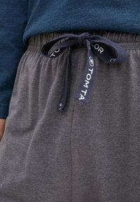 Shorts en coton gris avec une taille élastique et un cordon de serrage bleu marine arborant le logo "TOM TAYLOR". Texture lisse, style décontracté, détails minimalistes.