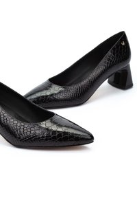 Zapatos de tacón alto negros con punta afilada, que presentan una textura de cocodrilo y un acabado brillante. El tacón cuadrado añade estabilidad.