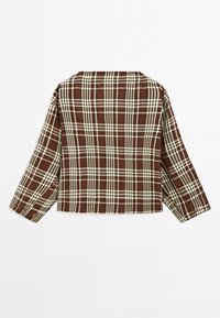 Chemise à carreaux marron et beige à manches longues et coupe ample, vue de dos sur fond blanc.