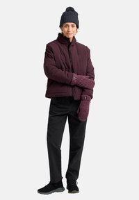Maroon padded jacket, black pants, knitted navy beanie, and purple mittens on a person. Textured fabric and cropped design noted.